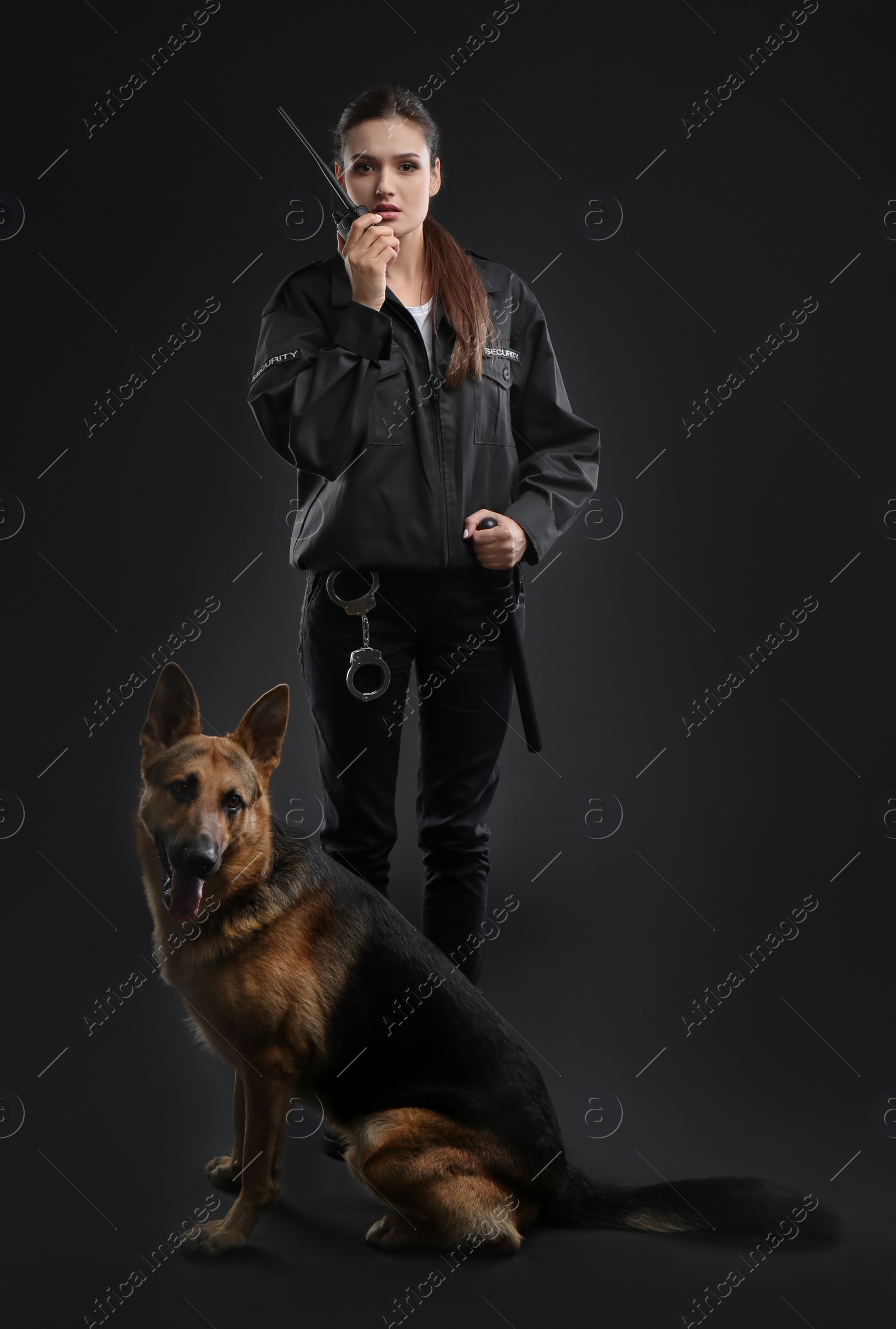 Photo of Female security guard with dog on dark background