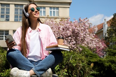 Young woman listening to audiobook in park