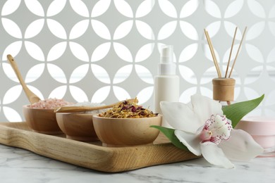 Photo of Beautiful composition with different spa products and orchid on white marble table