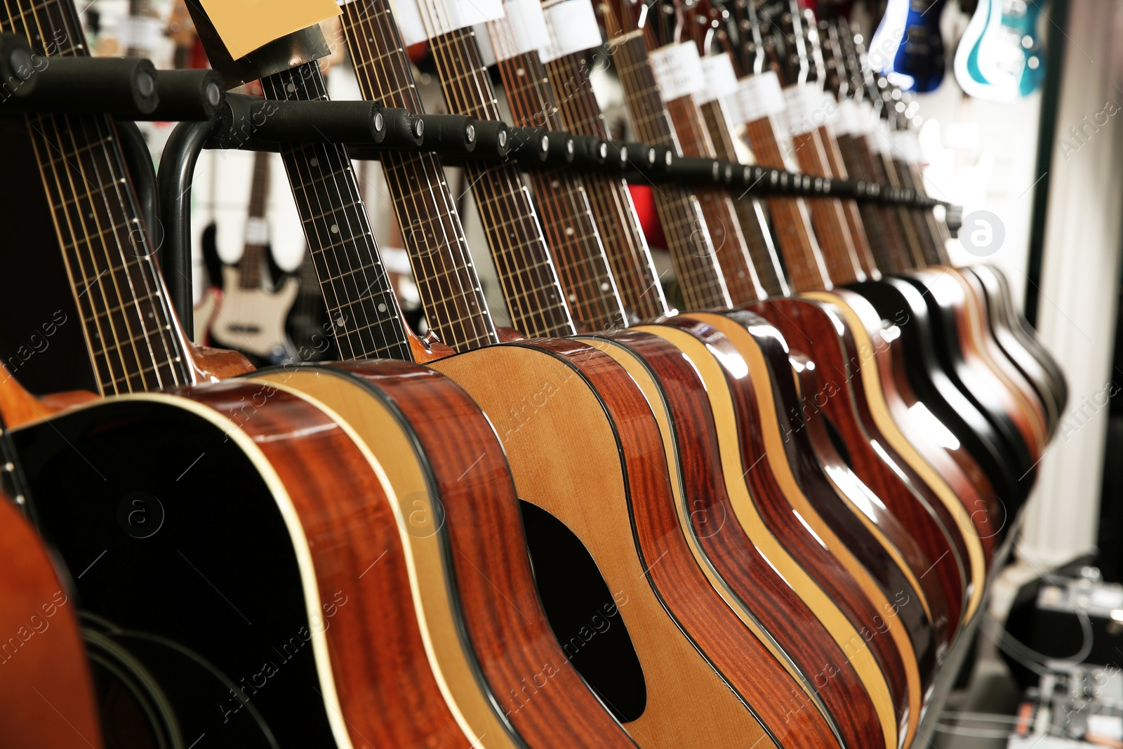 Photo of Row of different guitars in music store, closeup