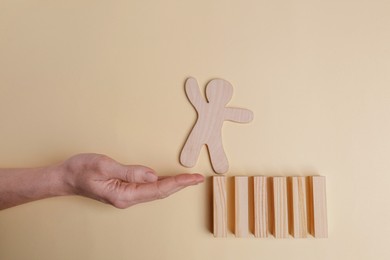 Photo of Woman holding hand to help human figure overcome abyss on beige background, closeup. Relationships, support and deal concepts