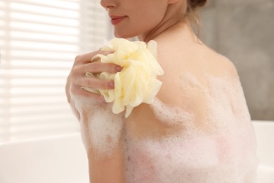 Woman taking bath with shower gel in bathroom, closeup