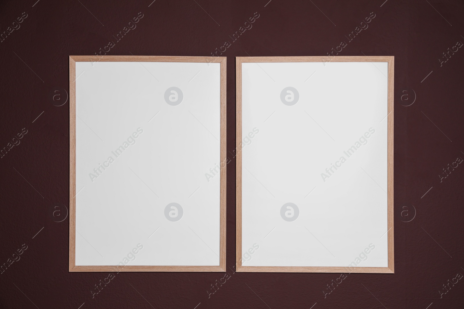 Photo of Empty frames on brown wall. Mockup for design