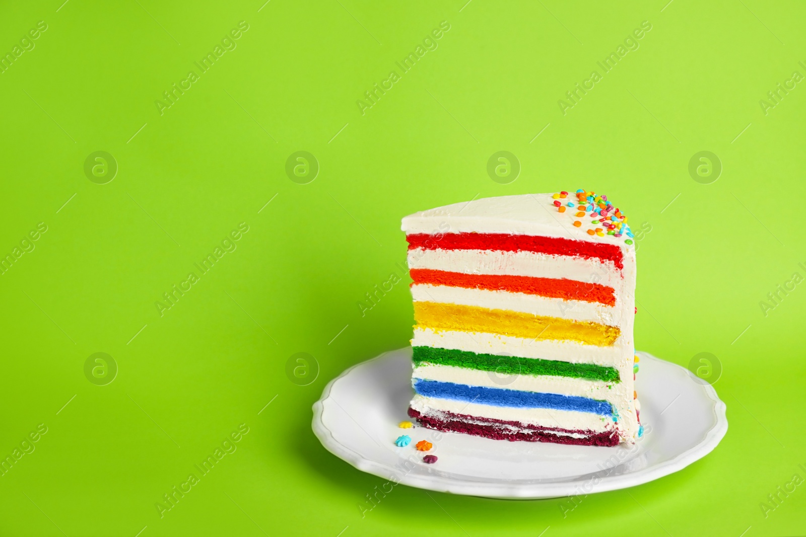 Photo of Slice of delicious rainbow cake on color background