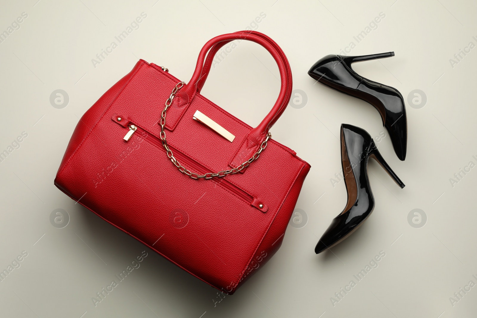 Photo of Stylish woman's bag and shoes on light background, flat lay