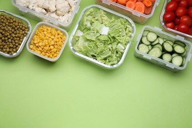 Photo of Plastic and glass containers with different fresh products on light green background, flat lay. Space for text