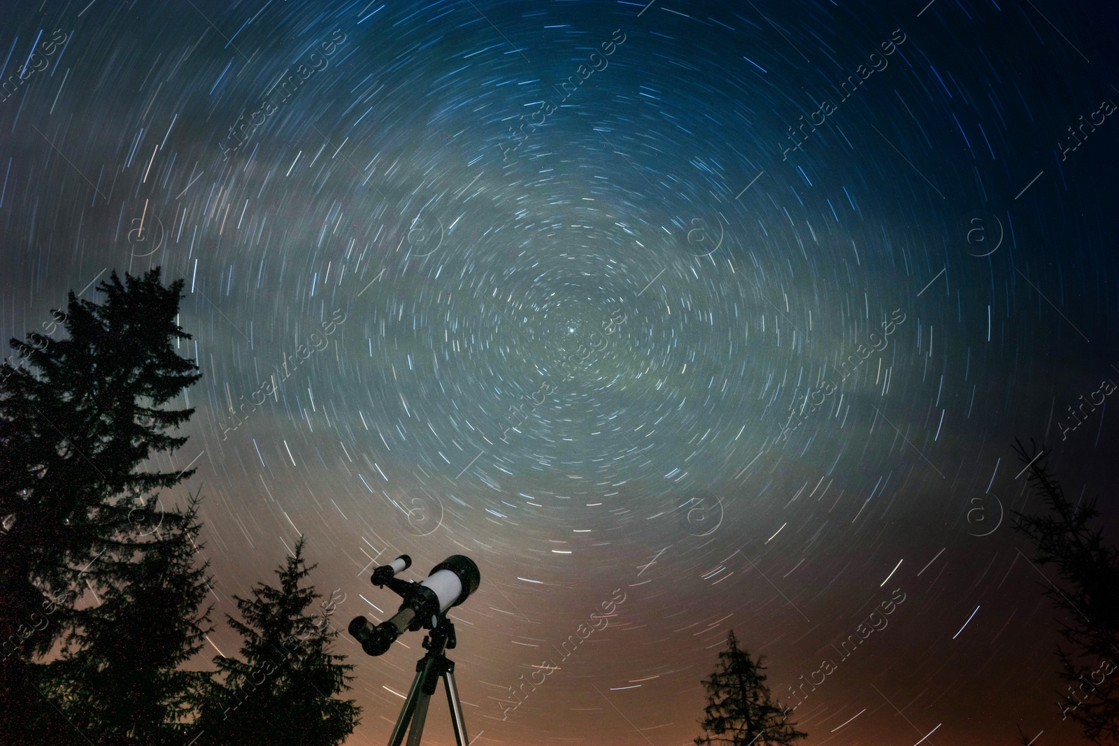 Photo of Modern telescope under night sky with star trails outdoors, low angle view. Learning astronomy