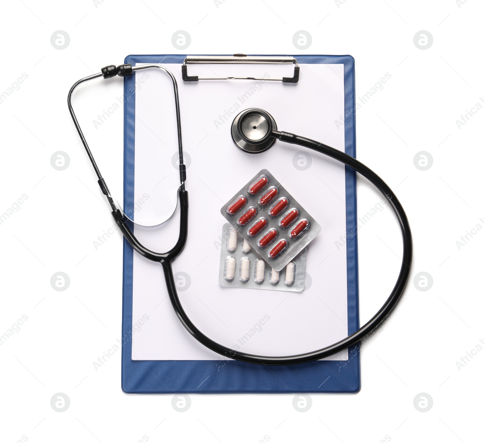 Photo of Clipboard, pills and stethoscope on white background, top view