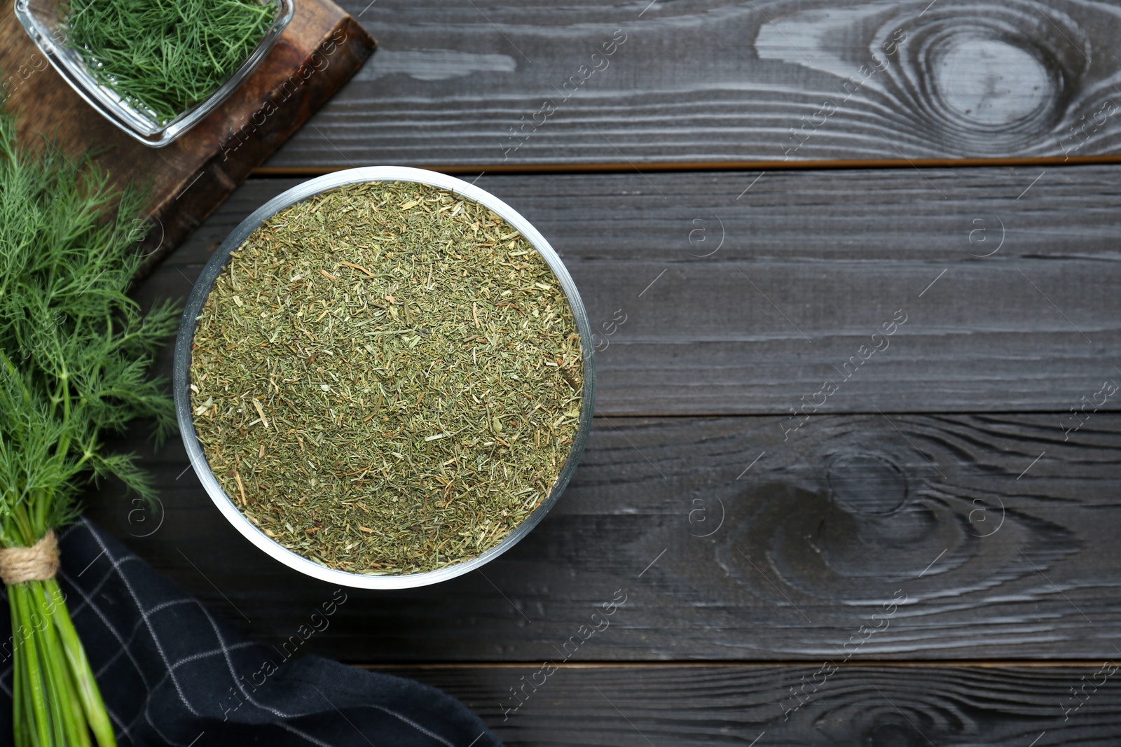 Photo of Dried and fresh dill on black wooden table, flat lay. Space for text