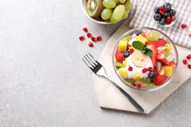 Photo of Delicious fruit salad on light grey table, flat lay. Space for text