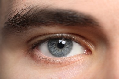Photo of Closeup view of young man with beautiful grey eyes