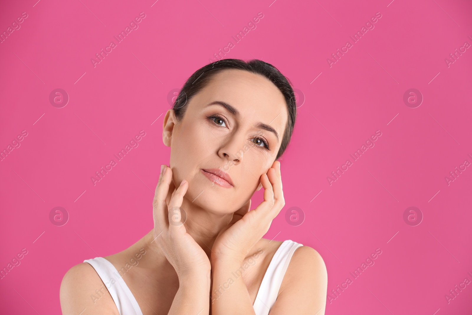 Photo of Portrait of beautiful mature woman on pink background