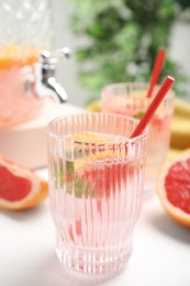 Photo of Delicious refreshing drink with grapefruit on white table