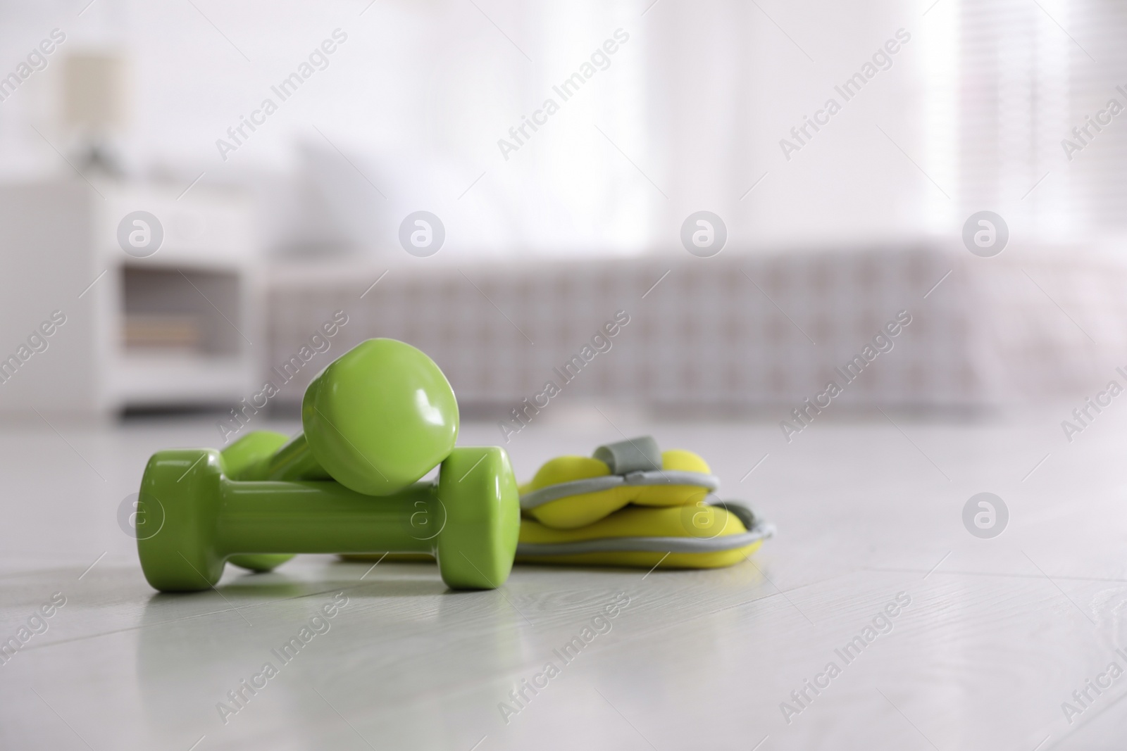 Photo of Dumbbells and weights on floor in room, space for text. Home fitness