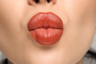 Photo of Closeup view of woman with coral lipstick