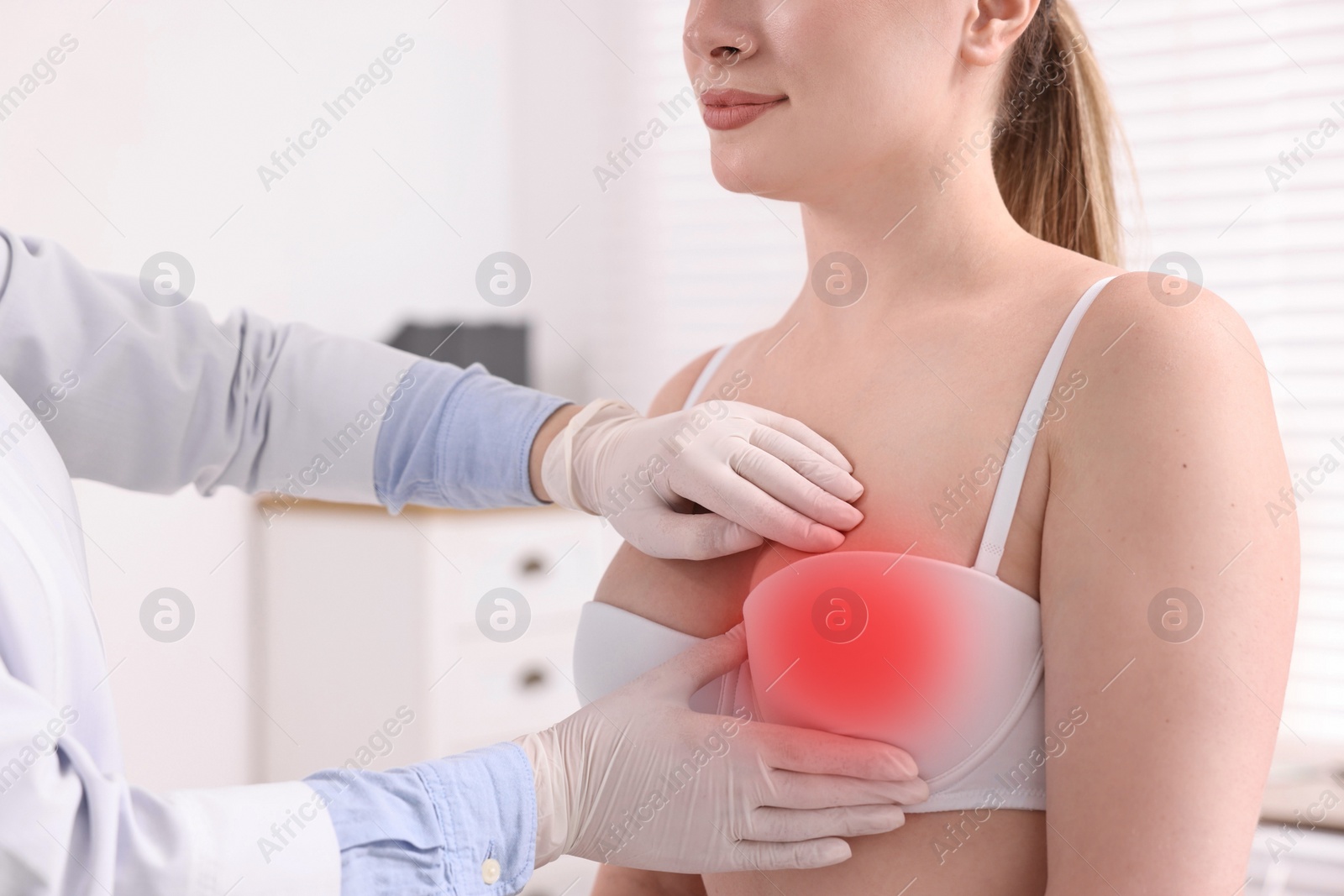 Image of Mammologist checking young woman's breast in hospital, closeup