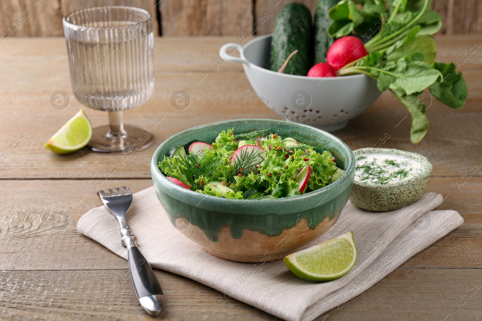 Photo of Delicious salad with radish, lettuce and dill served on wooden table