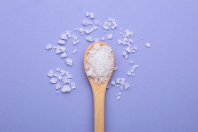 Photo of Spoon with sea salt on violet background, top view