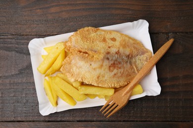 Photo of Delicious fish and chips served on wooden table, top view