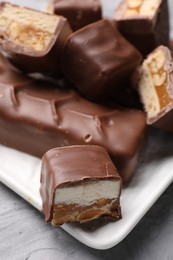 Photo of Tasty chocolate bars with nougat on table, closeup