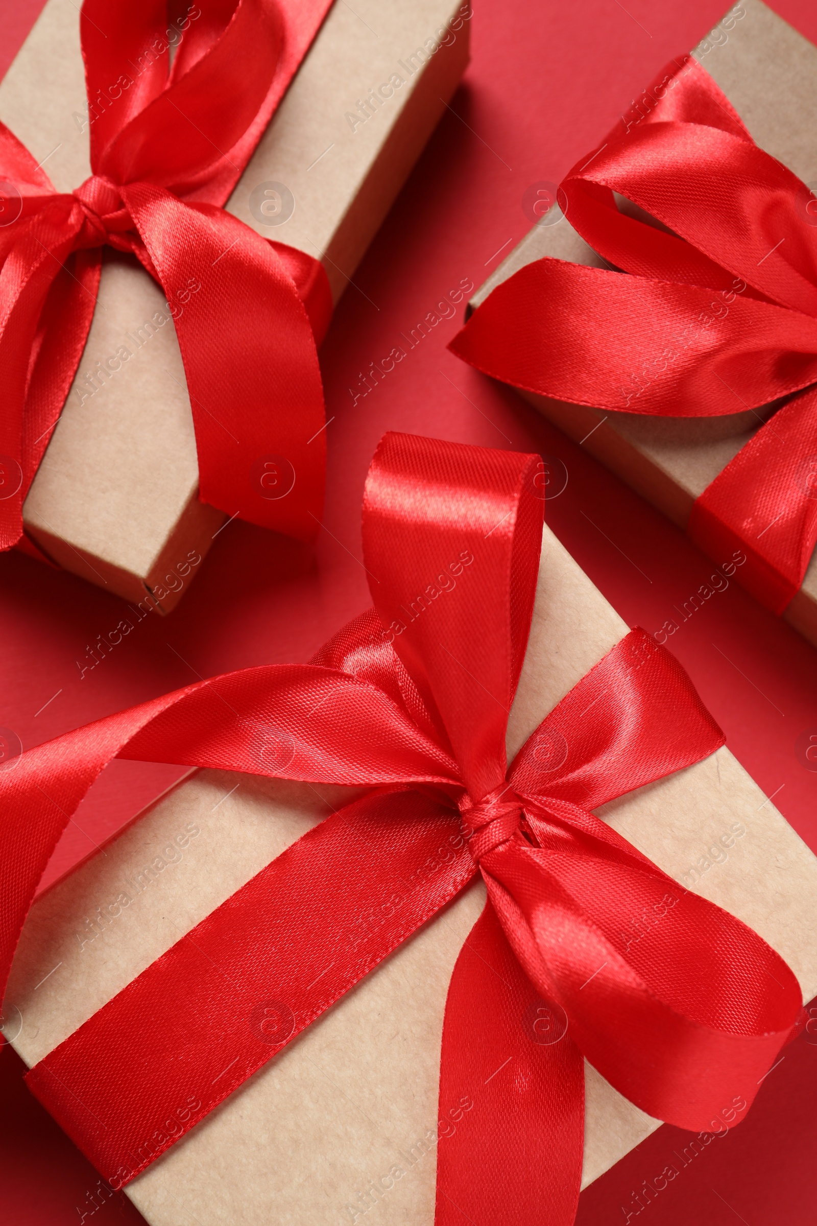 Photo of Beautiful gift boxes on red background, flat lay