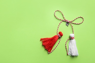 Photo of Traditional martisor on green background, top view with space for text. Beginning of spring celebration