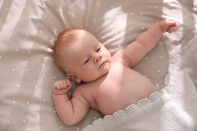 Photo of Cute little child lying in cot, above view. Healthy baby
