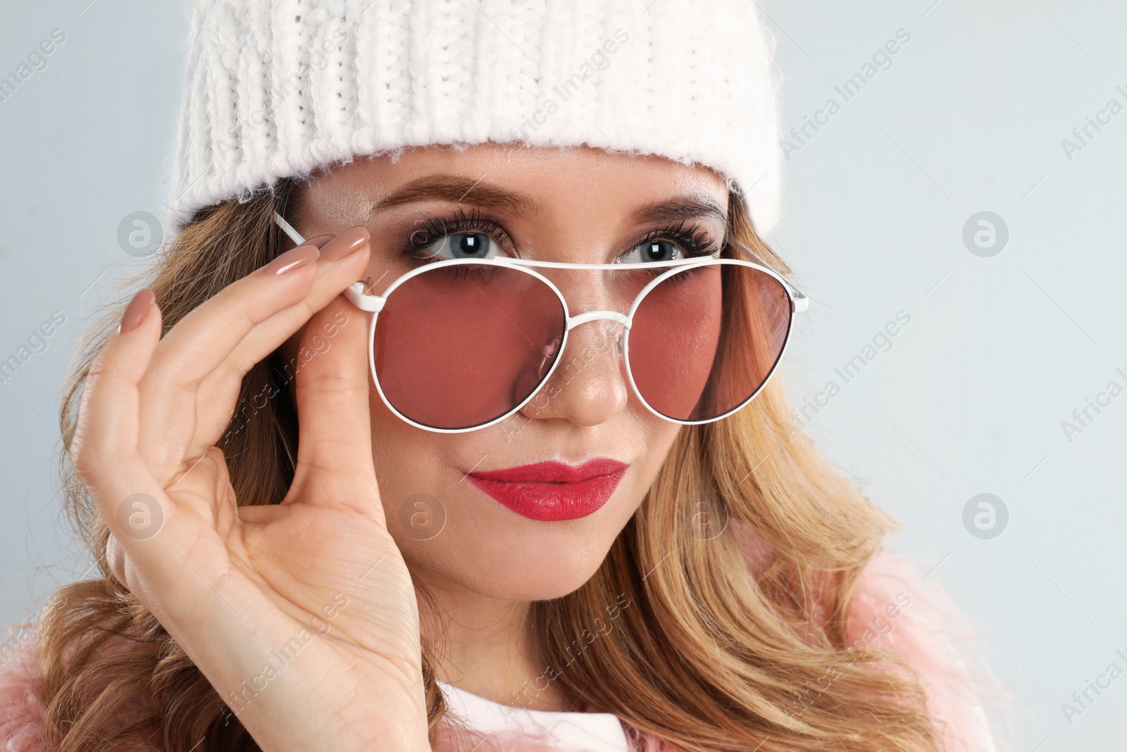 Photo of Young woman wearing stylish sunglasses on light grey background