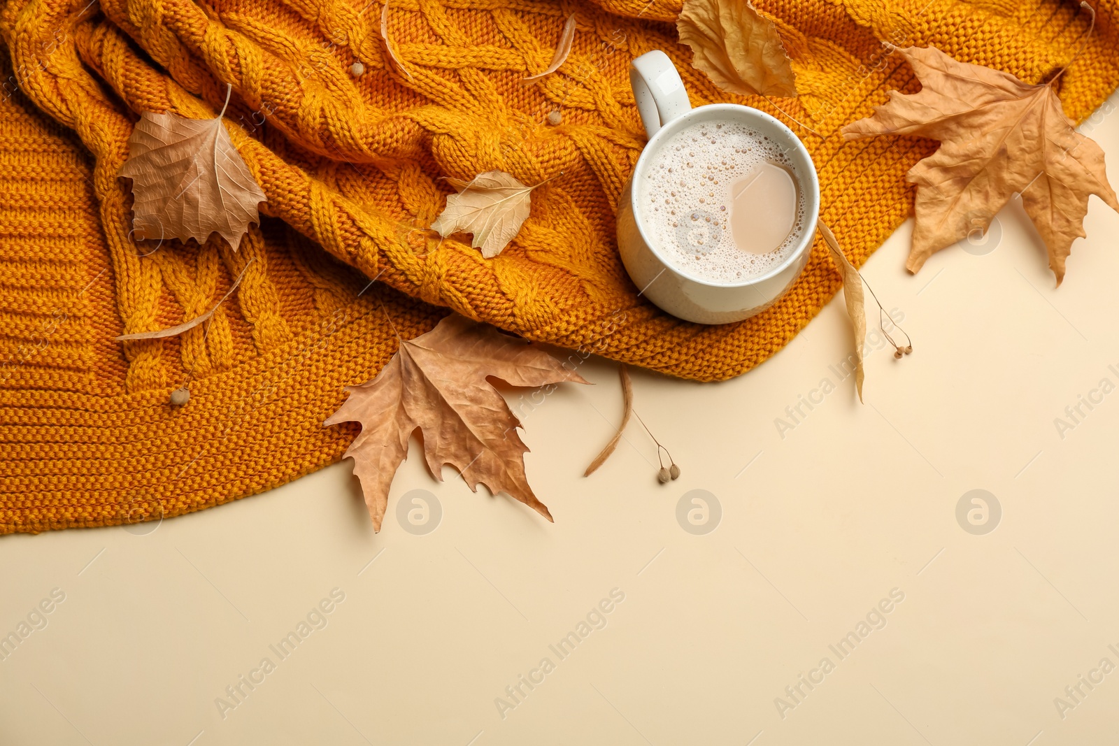 Photo of Flat lay composition with coffee and warm plaid on beige background, space for text