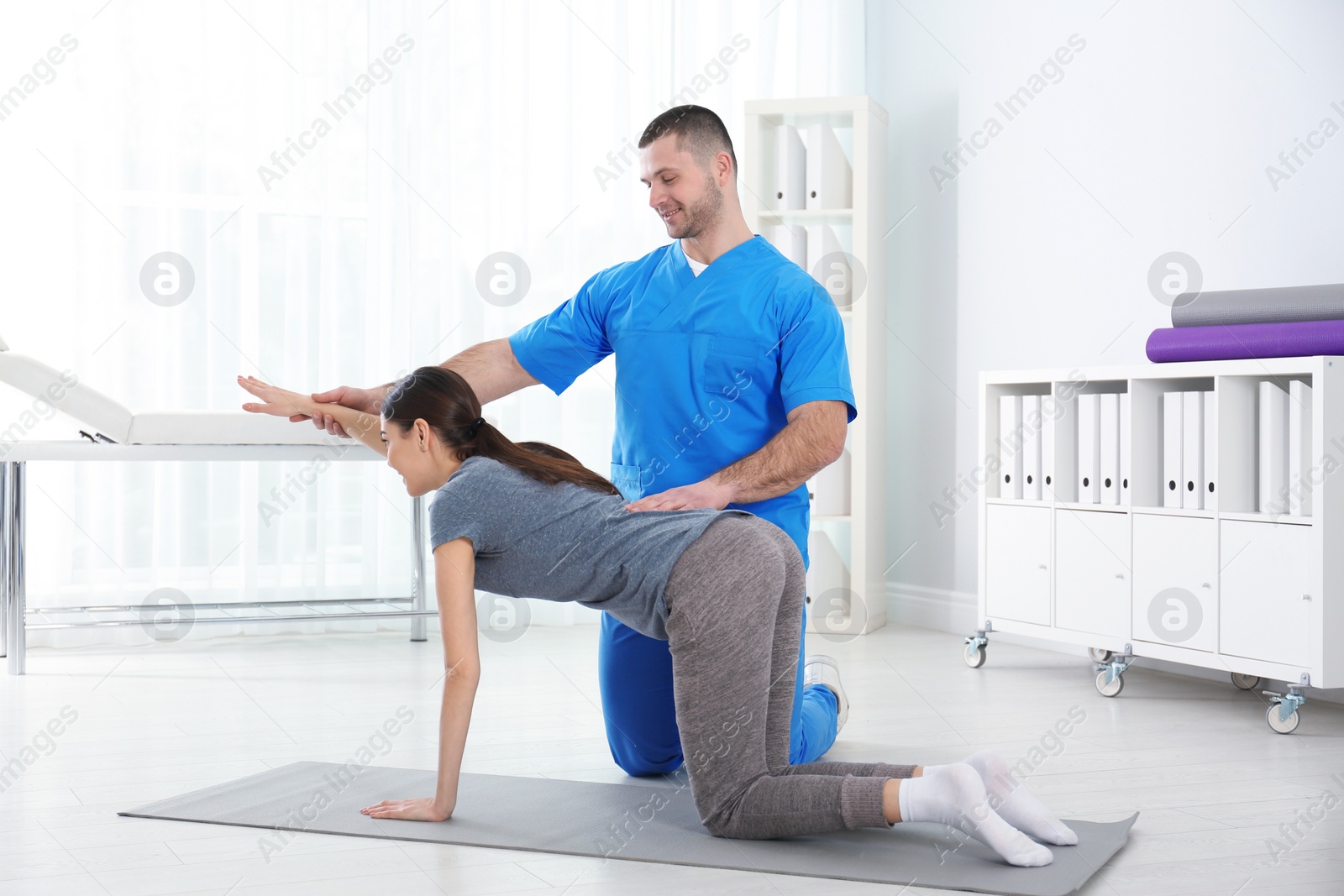 Photo of Doctor working with patient in hospital. Rehabilitation exercises