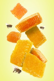 Image of Pieces of honeycomb in air and bees flying on yellowish green background