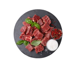 Photo of Slate plate with cut fresh beef meat, basil leaves and spices isolated on white, top view