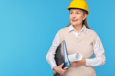 Photo of Architect in hard hat with draft and folder on light blue background, space for text