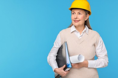 Architect in hard hat with draft and folder on light blue background, space for text