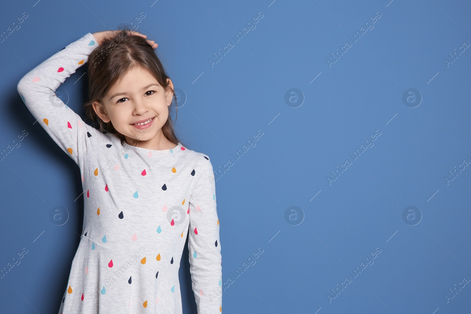 Photo of Little girl measuring her height on color background