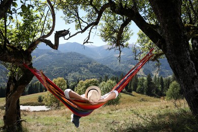 Photo of Man resting in hammock outdoors on sunny day