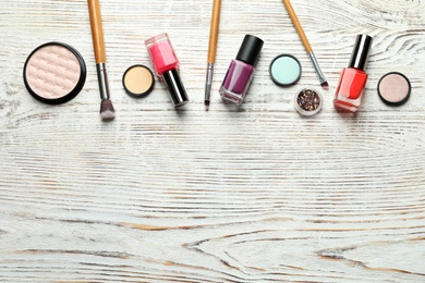 Photo of Flat lay composition with decorative cosmetics on wooden background