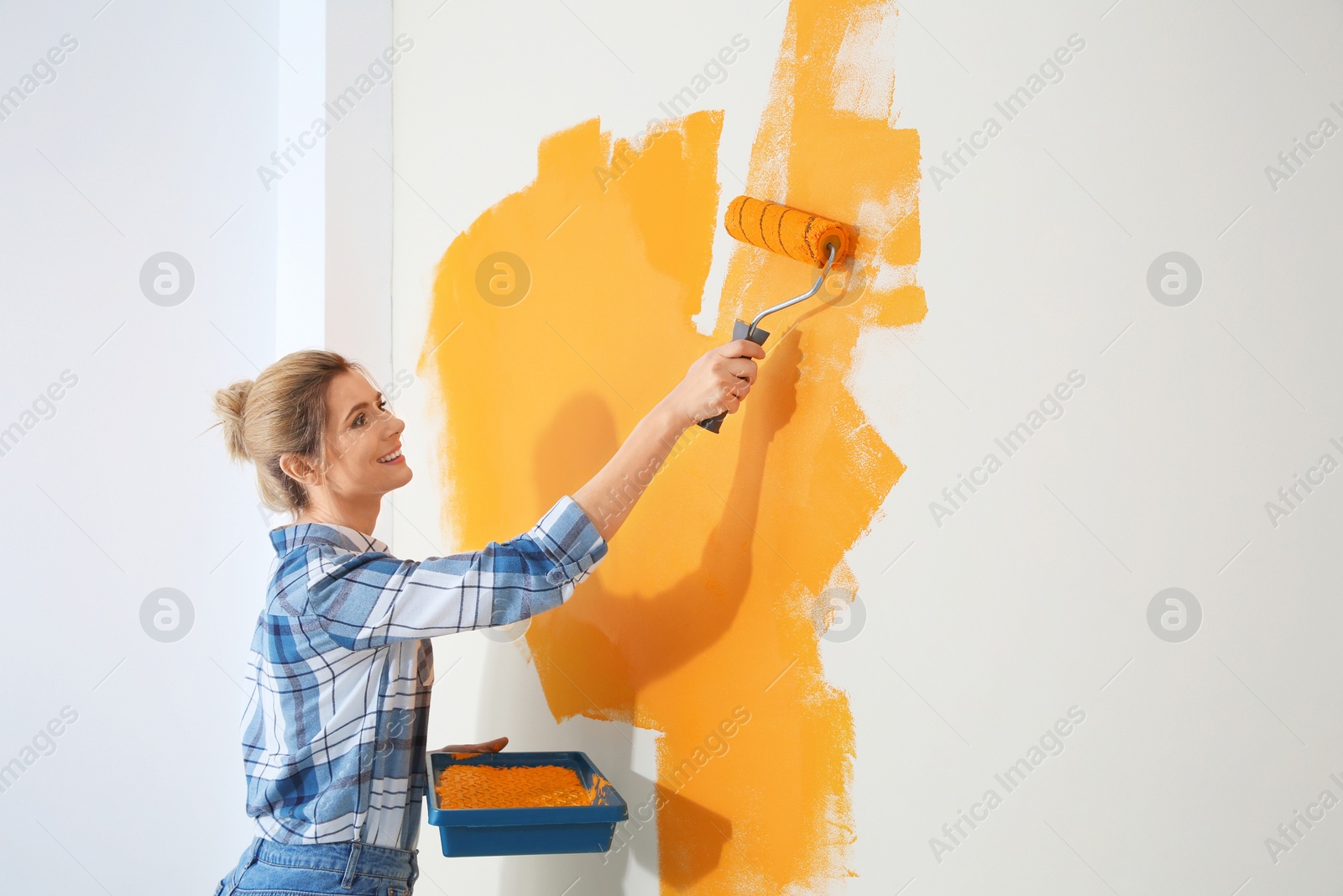 Photo of Happy woman painting wall indoors, space for text. Home repair