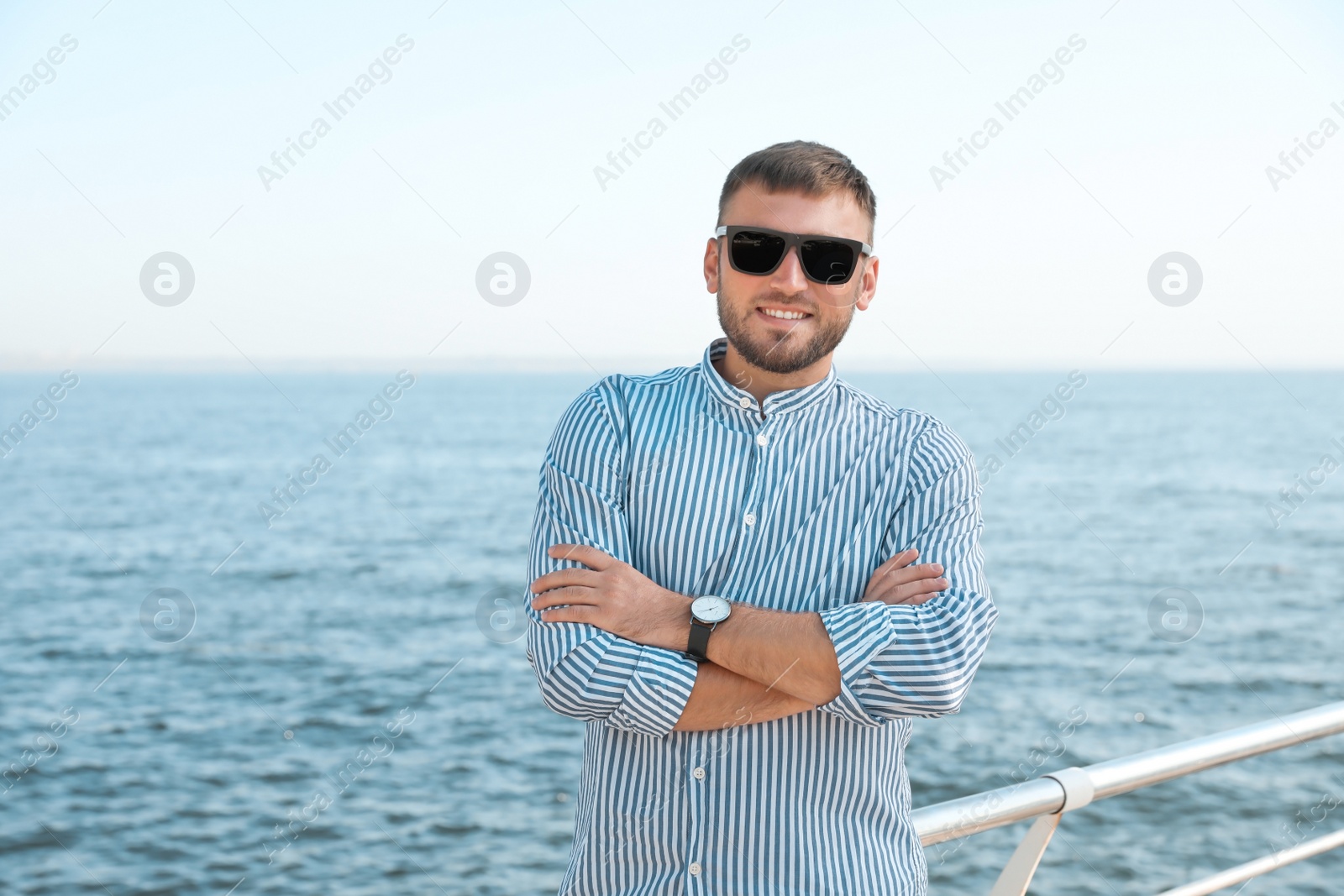 Photo of Portrait of handsome young man on sea pier