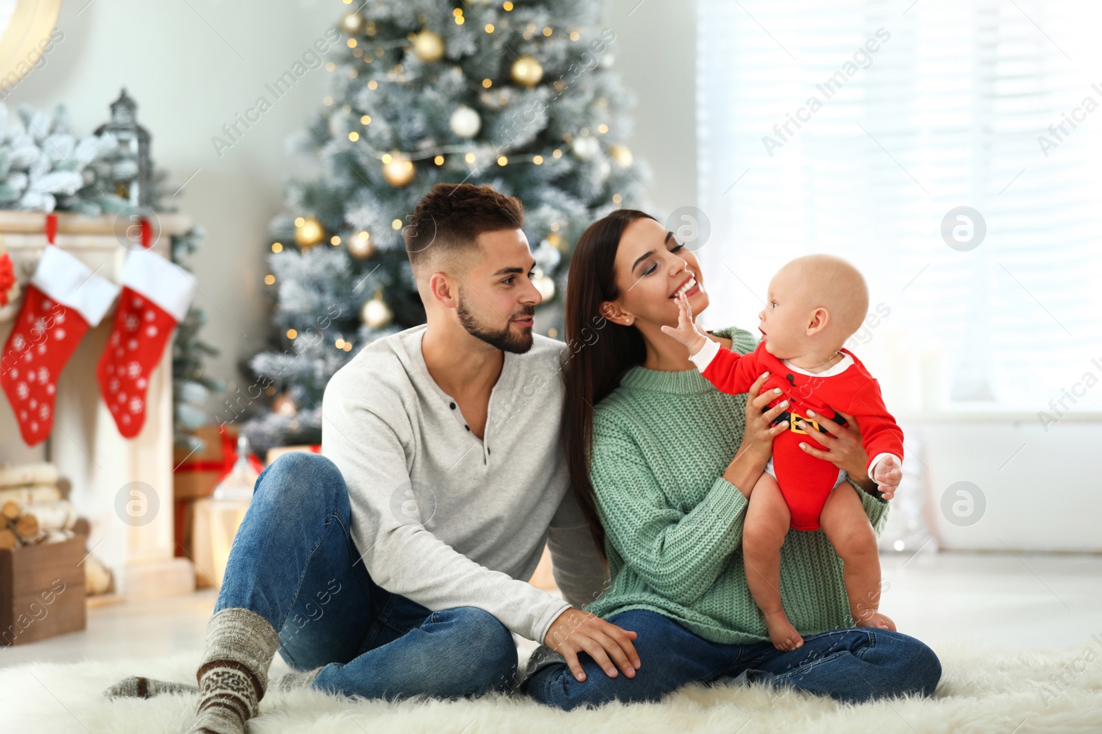 Photo of Happy family with cute baby at home. Christmas celebration