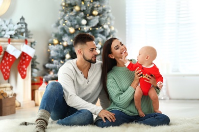 Photo of Happy family with cute baby at home. Christmas celebration