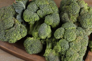 Tray with fresh raw broccoli on wooden table, closeup