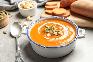 Photo of Bowl of tasty sweet potato soup served on table