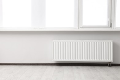 Photo of Modern radiator in room, space for text. Central heating system