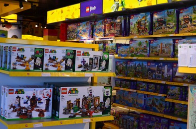 Photo of AMSTERDAM, NETHERLANDS - SEPTEMBER 10, 2022: Rack with different lego constructor sets in shop