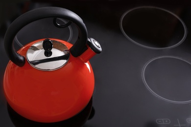 Modern kettle with whistle on stove, space for text