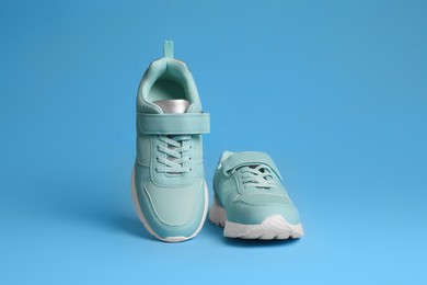 Photo of Pair of stylish sneakers on light blue background