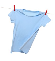 One light blue t-shirt drying on washing line isolated on white