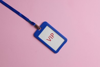 Plastic vip badge on pale pink background, top view