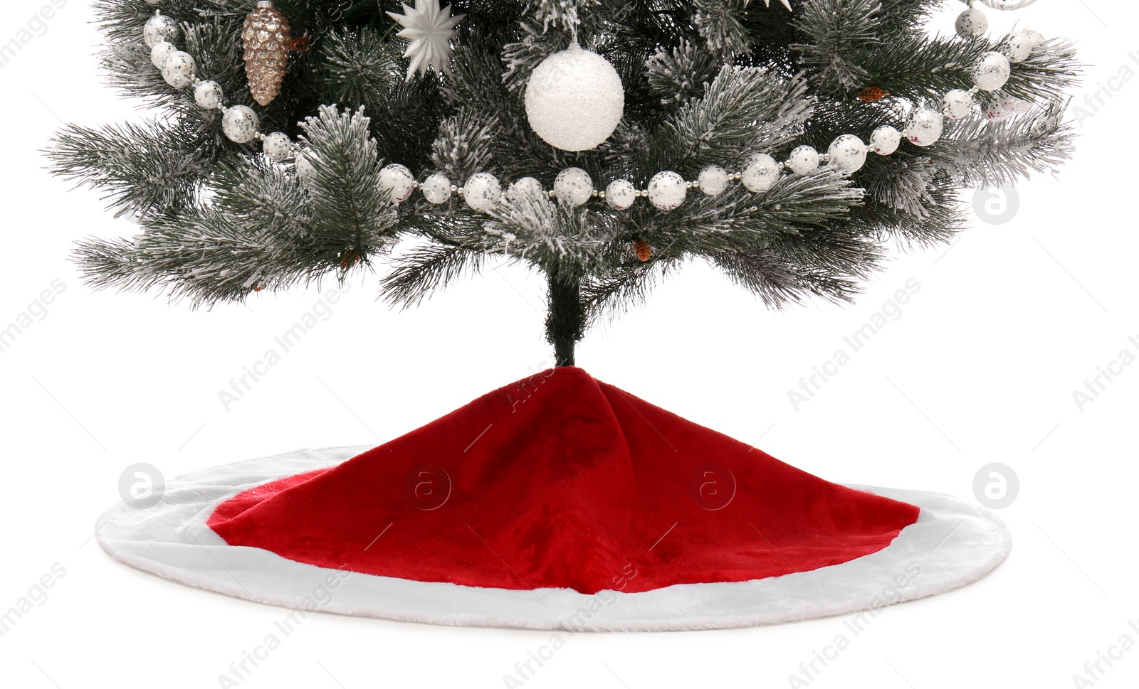 Photo of Decorated Christmas tree with red skirt on white background